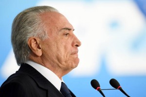 Brazilian President Michel Temer speaks during the signing ceremony of the decree that frees differential prices for payment in cash and with credit card at the Planalto Palace in Brasilia, on June 26, 2017.  Temer faces his own crisis with the prosecutor general expected to request formal corruption charges against the president Monday or Tuesday. / AFP PHOTO / EVARISTO SA